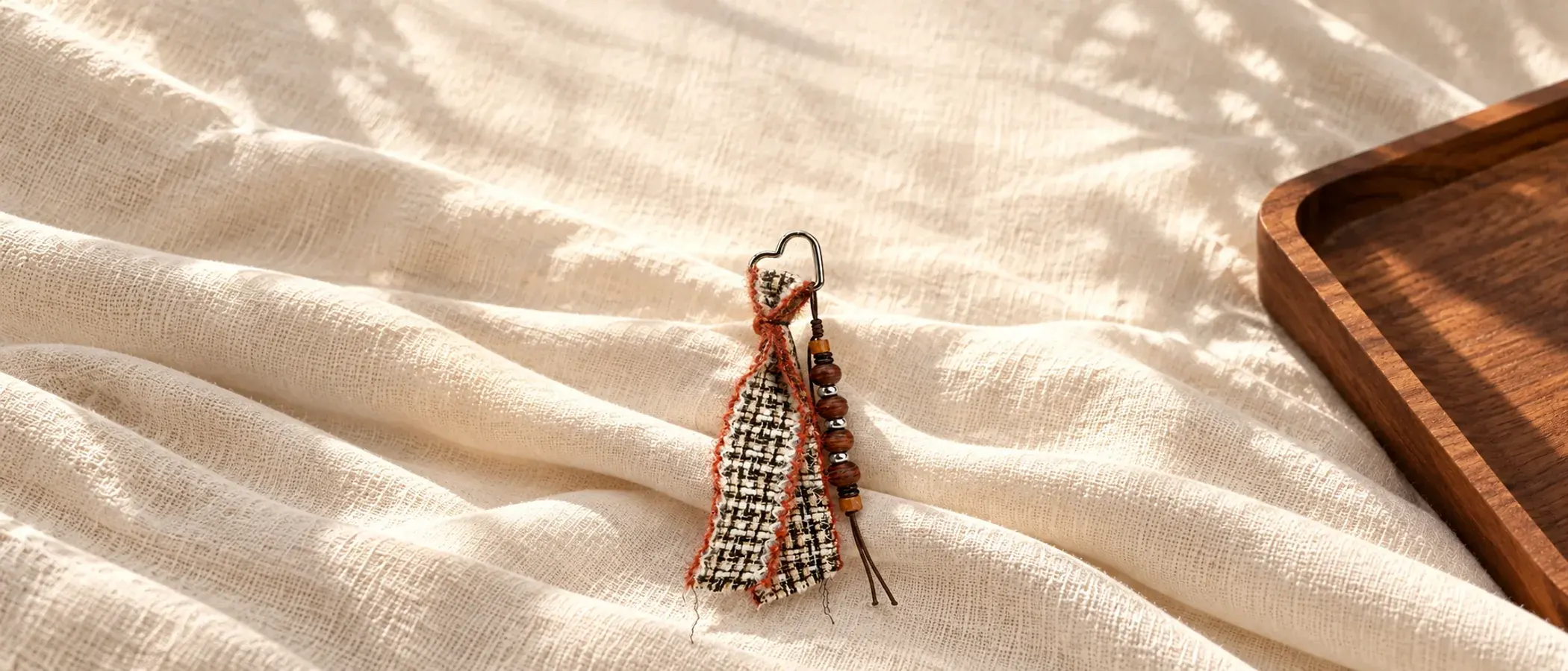 Rue ribbon and bead bag charm on cream linen