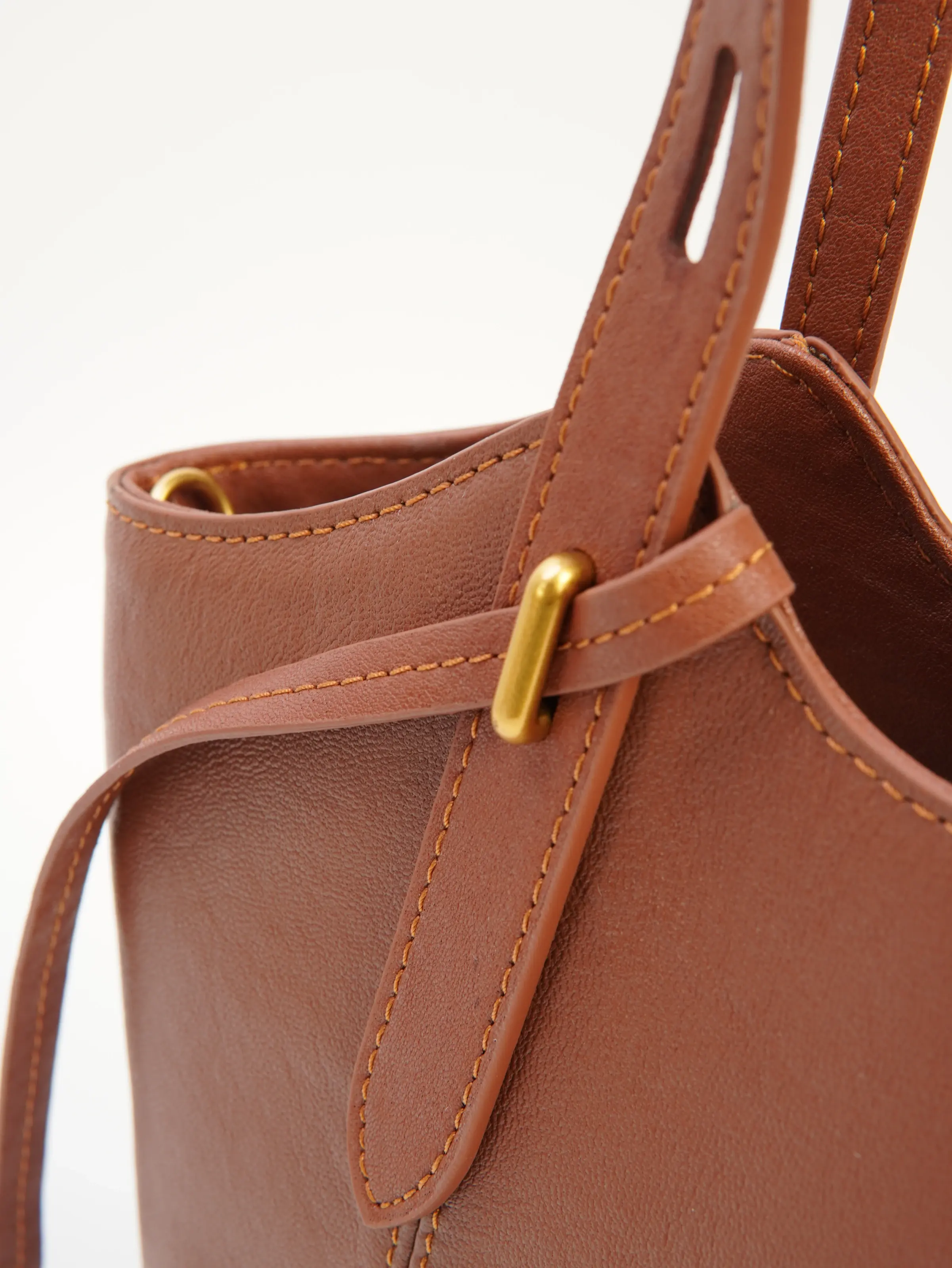 Close view of Nora handle, side tie and metal-tone detail