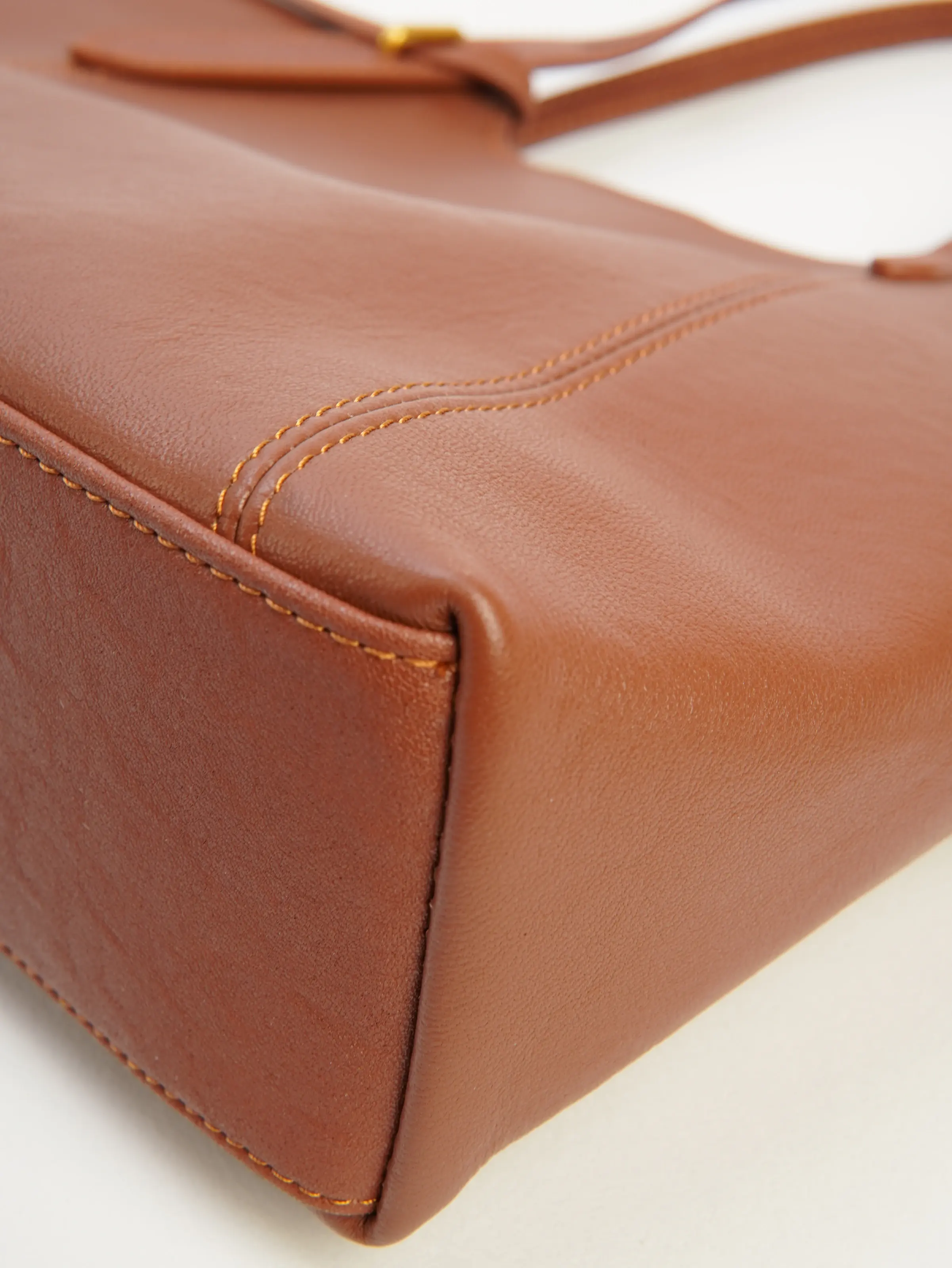 Base corner and stitching of Nora cognac tote bag