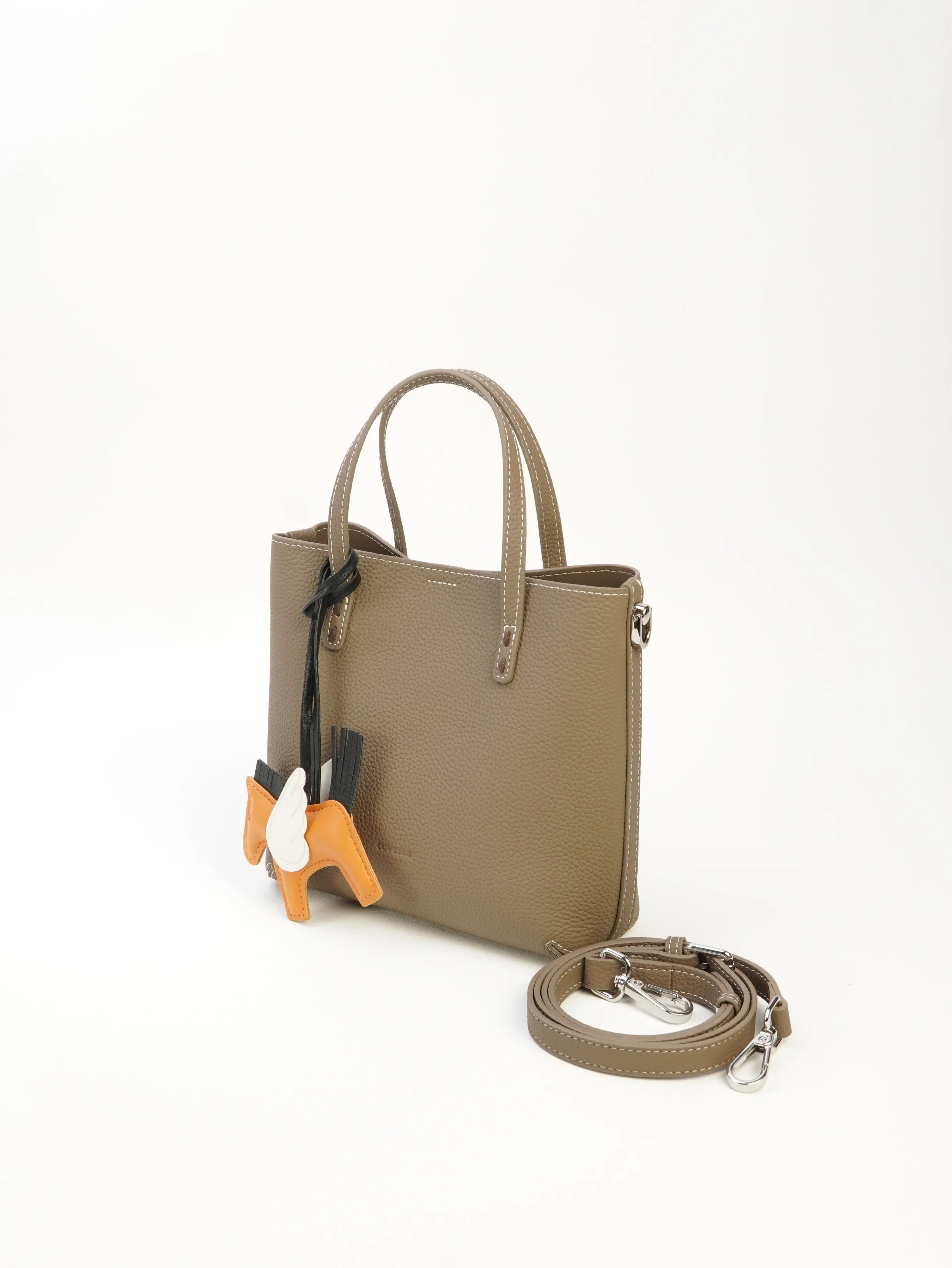 Lena taupe top-handle tote bag at an angle with an orange horse-shaped charm styled on its front