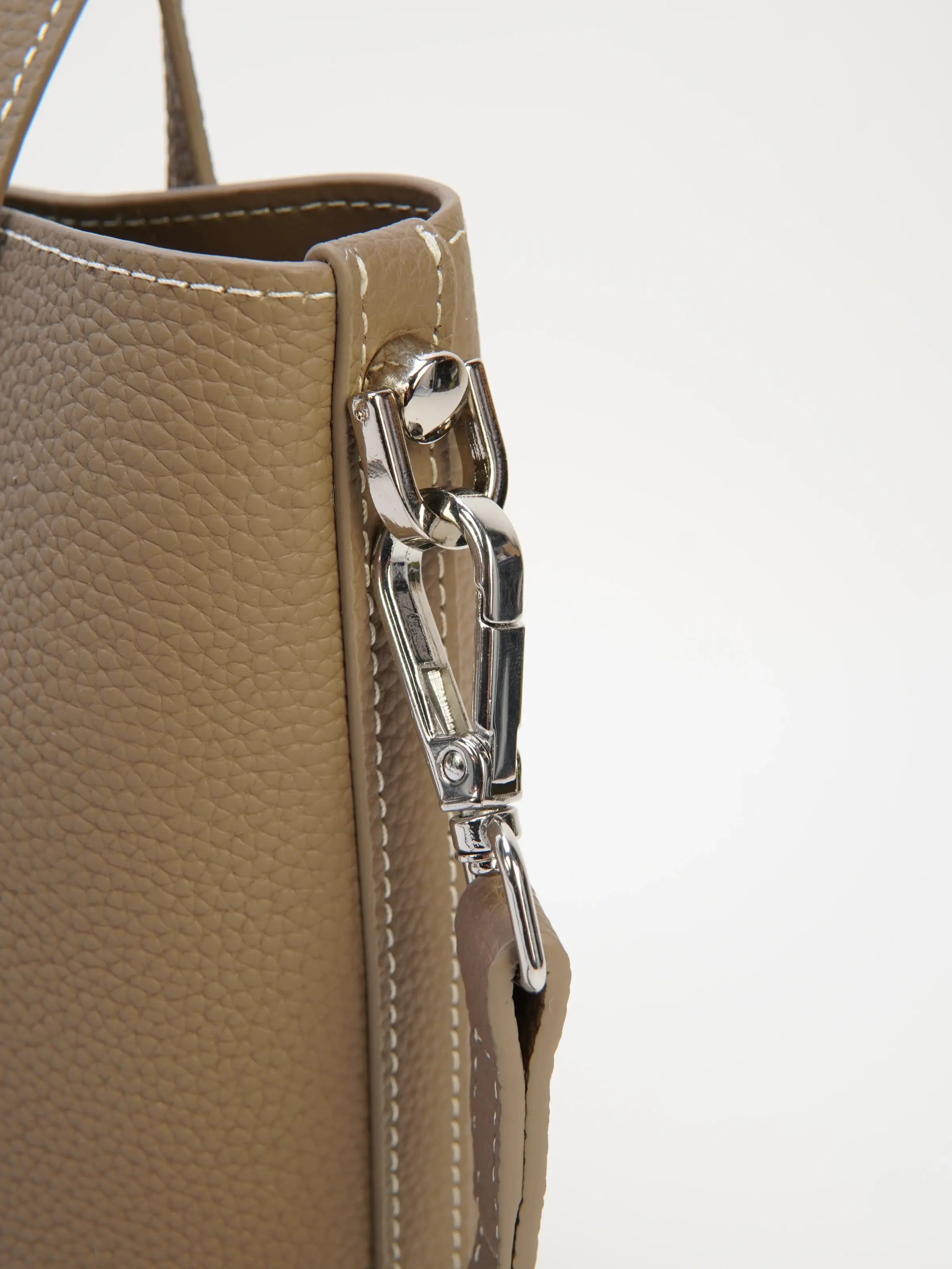 Close view of the Lena taupe tote side clip and contrast stitching