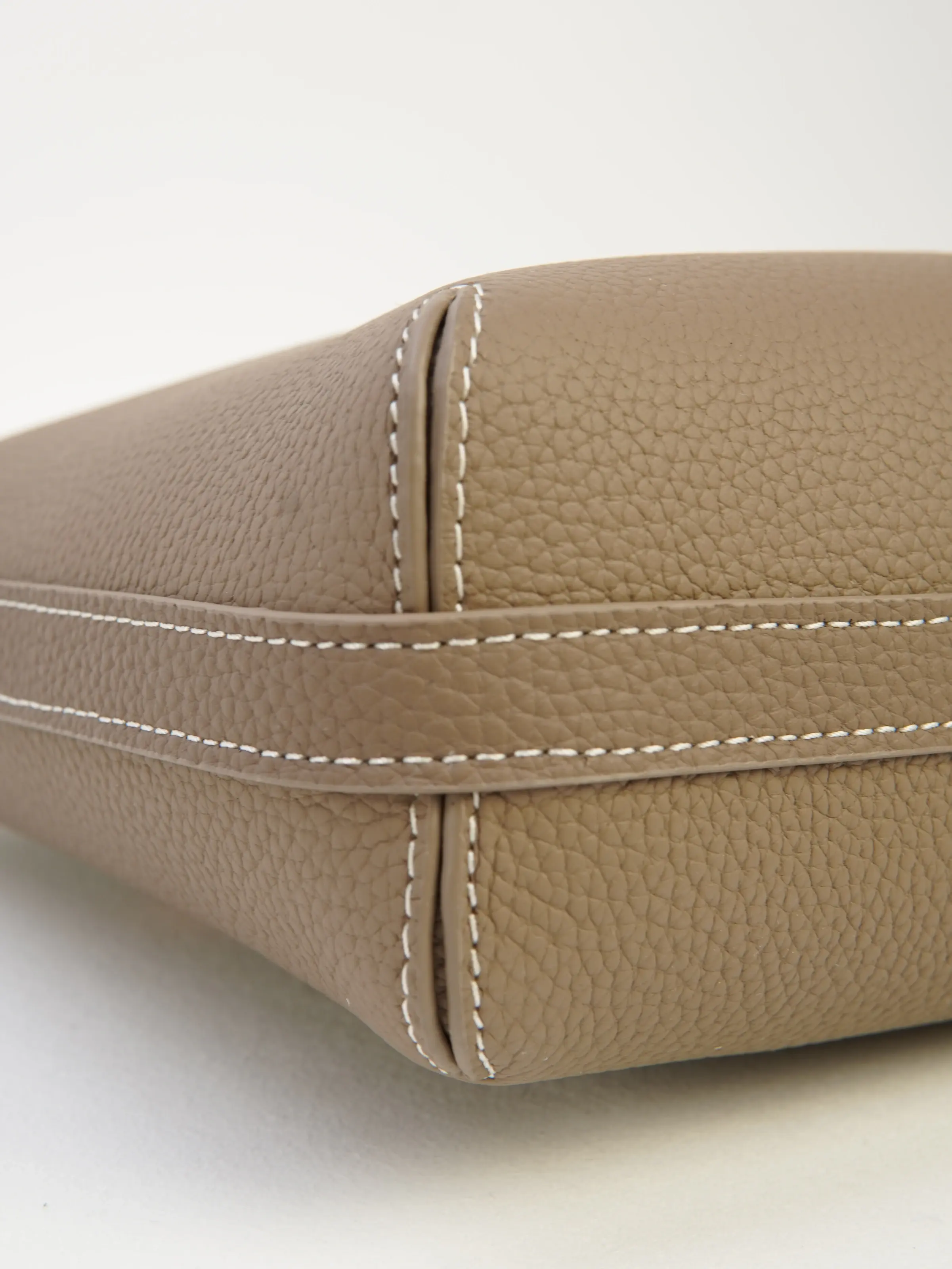 Close view of the Lena taupe tote base corner and contrast stitching