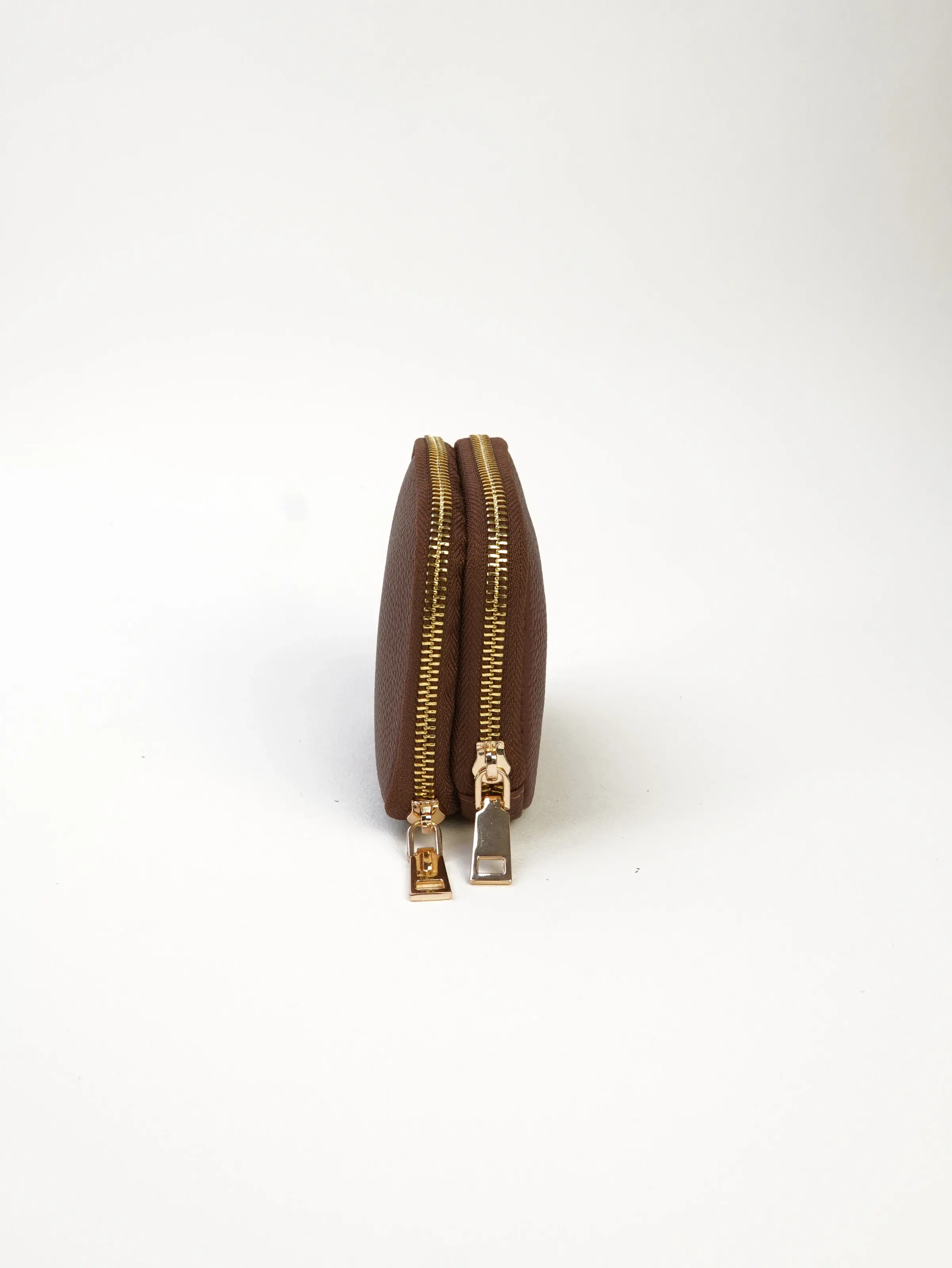 Side view of the Nia jewelry case showing two parallel gold-tone zipper tracks