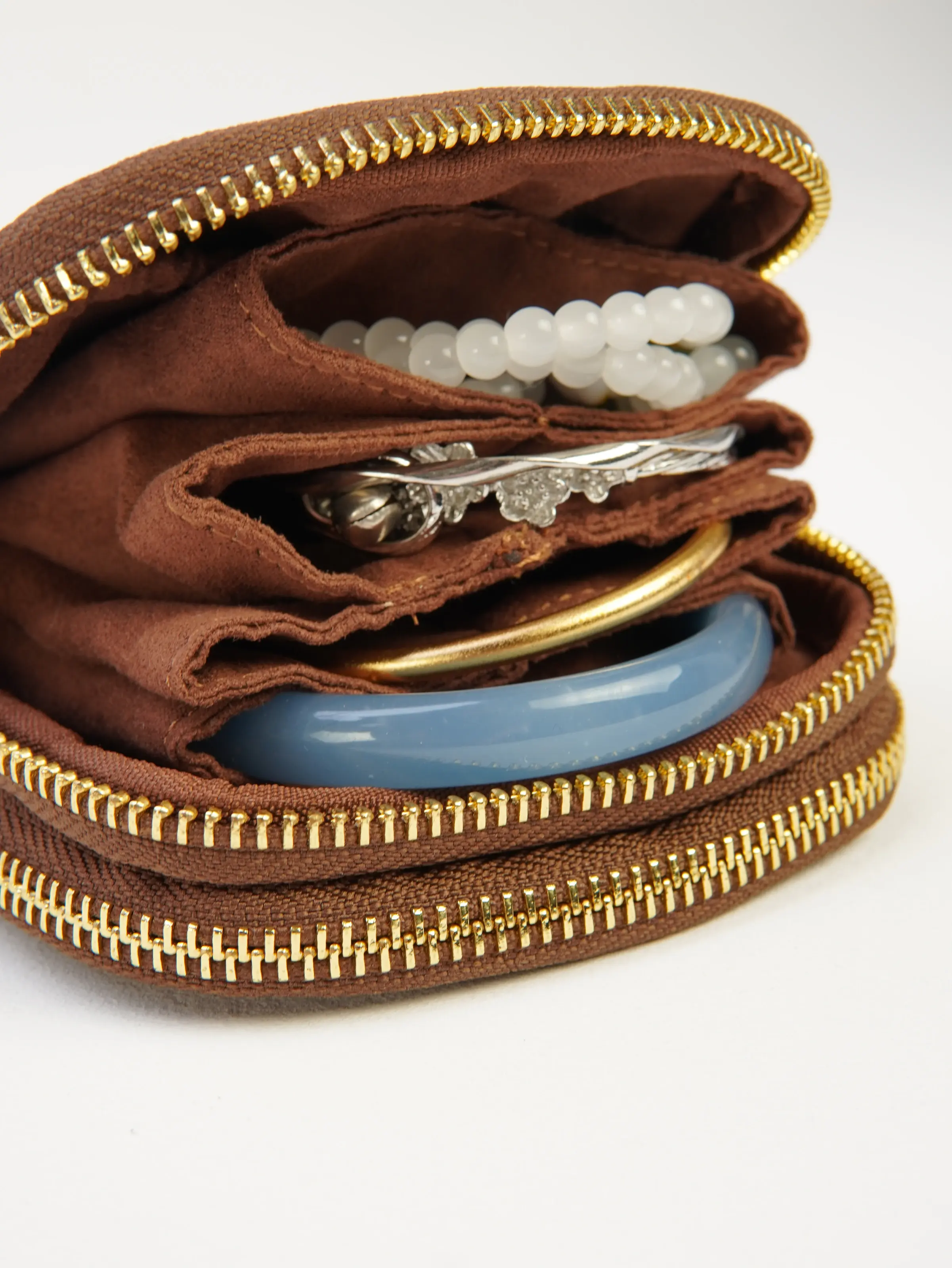 Open Nia jewelry case with divided interior and jewelry arranged for the photograph