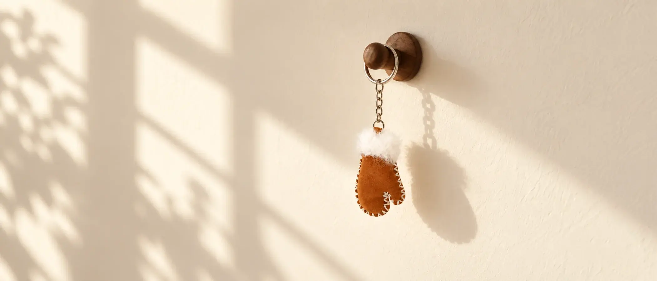 Milo mitten bag charm hanging from a wooden hook